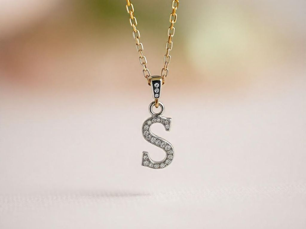 A sparkling initial pendant necklace with a letter charm adorned with diamonds, set against a soft, blurred background for an elegant look.